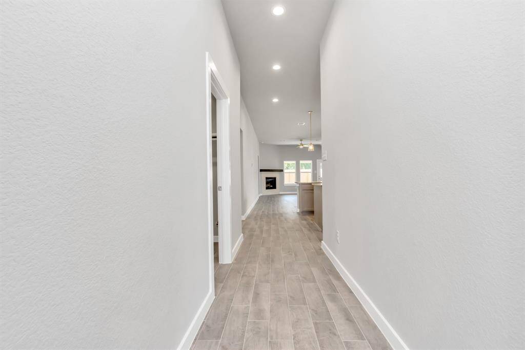 The majestic entryway allures with its high ceilings, embellished with sophisticated wood-look tile flooring and sleek oversized baseboards. Sample photo of completed home with similar floor plan. As-built interior colors and selections may vary.