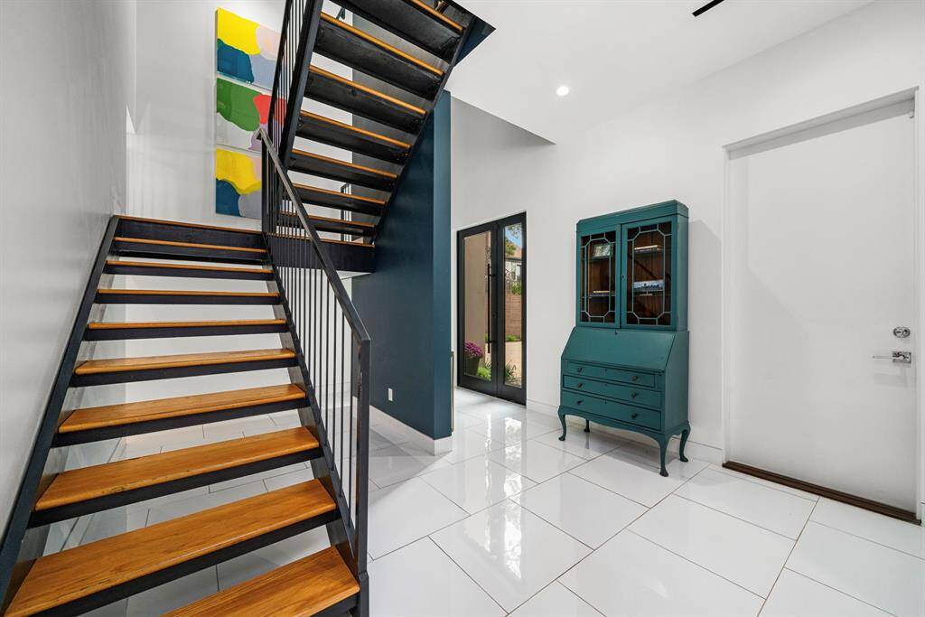 Upon entering, you are greeted by sleek large scale tile flooring that runs throughout the 1st floor. The exposed staircase going all the way to the 3rd floor contributes to the overall modern aesthetic of this home.