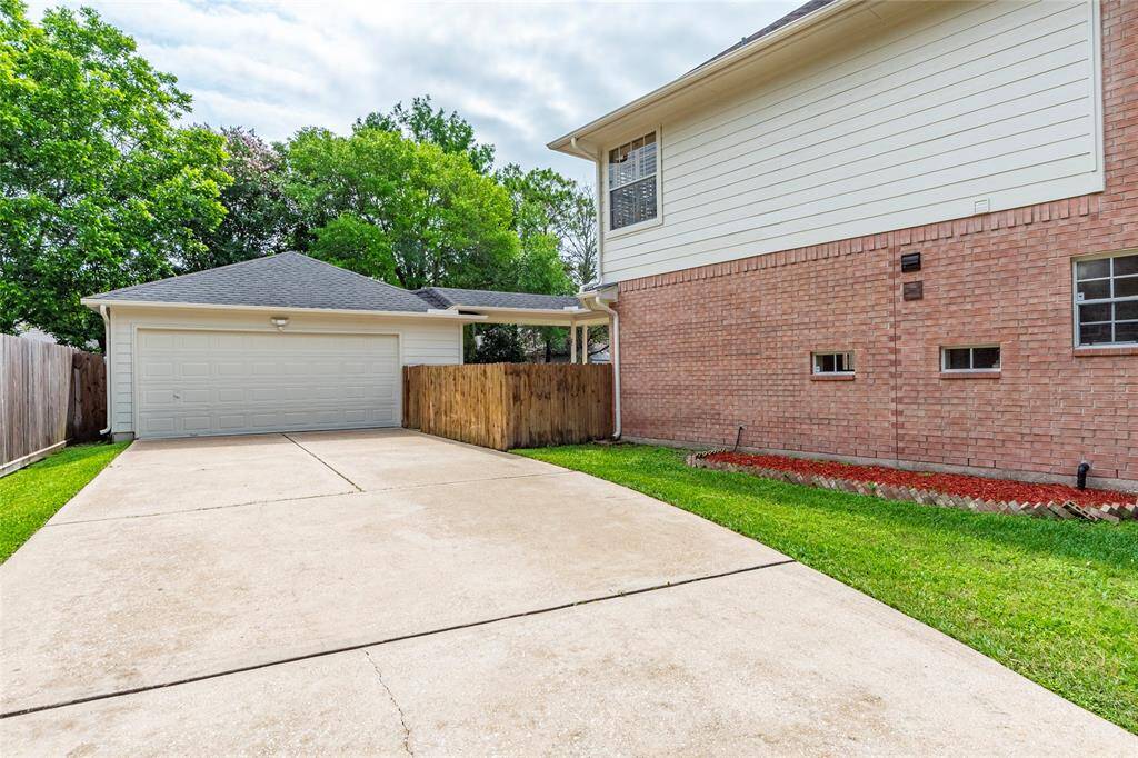The property offers ample driveway space and a welcoming suburban atmosphere. Extended driveway leads to the oversized 2 car detached garage with storage/workshop area.