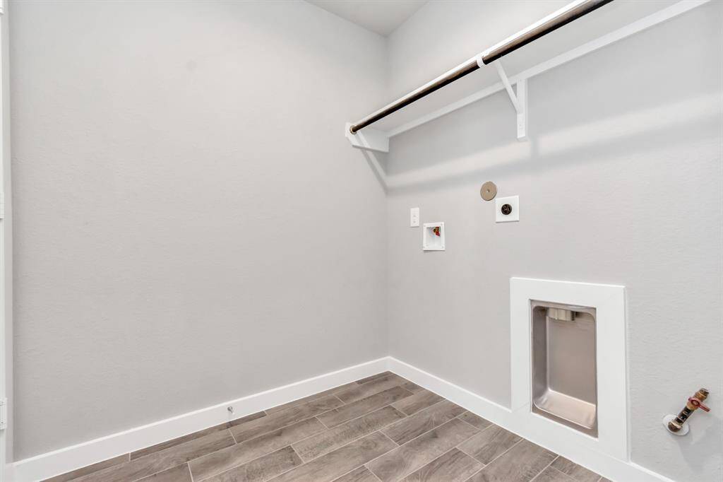 A perfect blend of functionality and comfort. Laundry room, thoughtfully equipped with shelving for effortless organization. Both gas and electric connections available. Sample photo of completed home with similar floor plan. As-built interior colors and selections may vary.