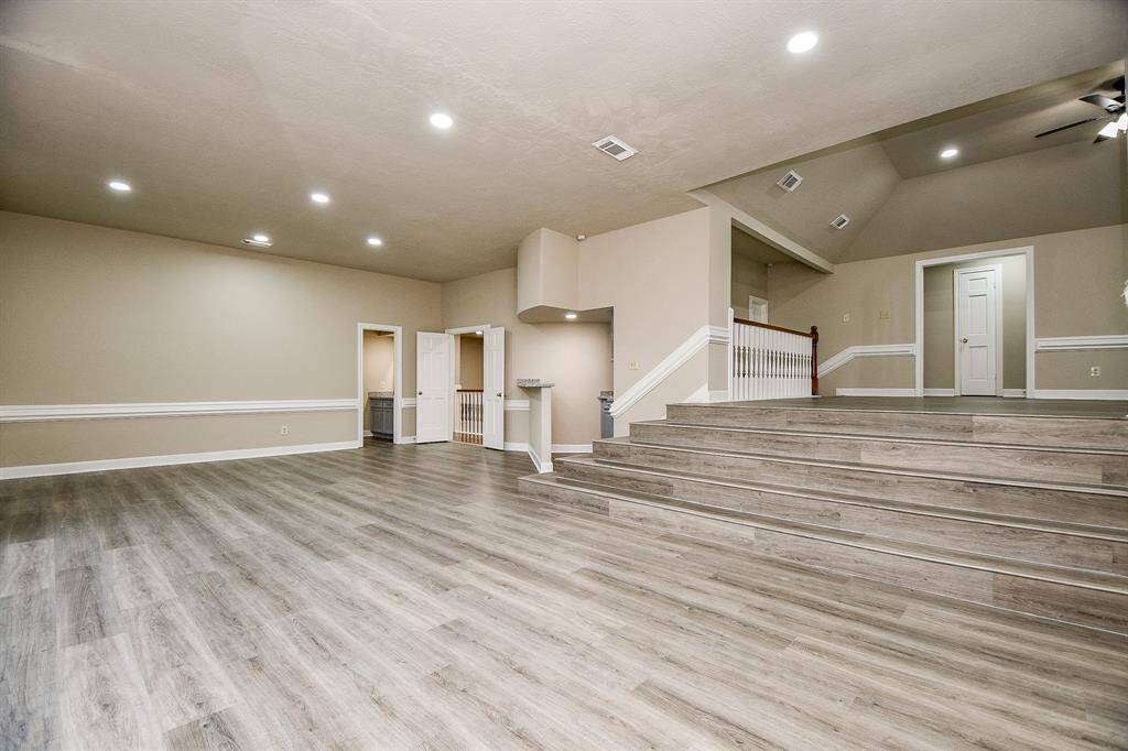A chef's dream, this expansive kitchen boasts abundant storage, a spacious island with a sleek new vent hood, and a walk-in pantry. A dedicated desk area provides a convenient workspace. Enjoy ample countertop space, including a luxurious quartz island and elegant black granite countertops throughout