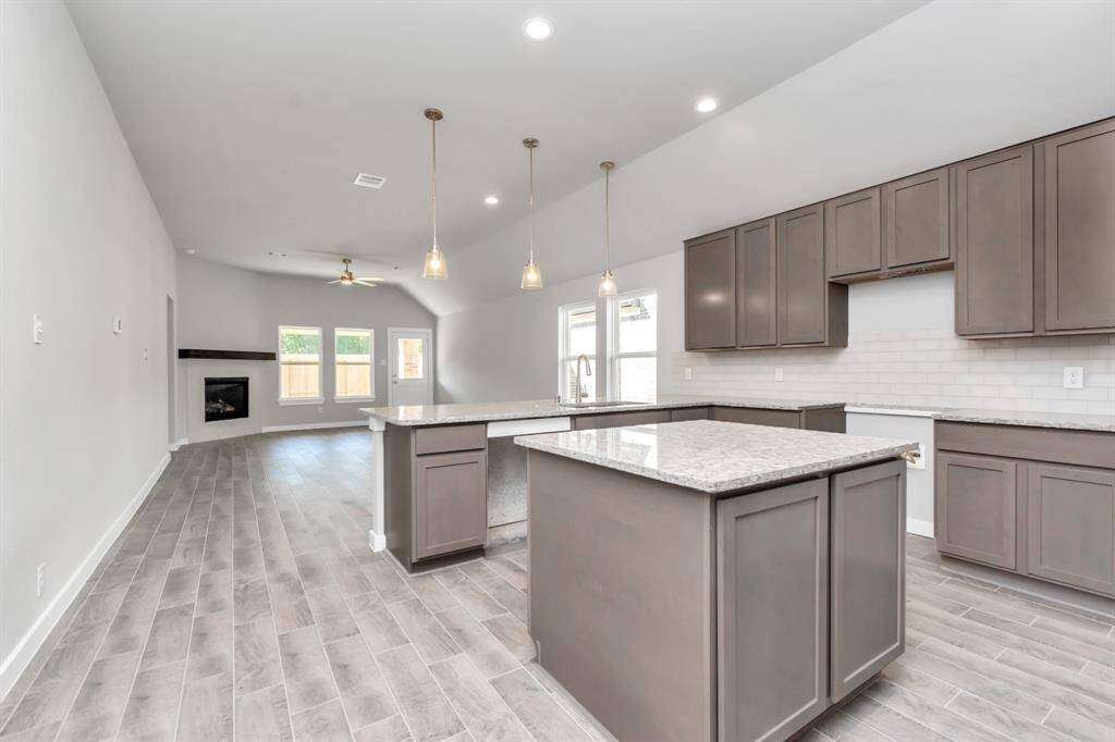 Welcome to a dream kitchen that exceeds expectations! This generously spacious layout boasts a massive granite island, high ceilings, soft-close cabinets, granite countertops, stainless steel appliances, a sleek tile backsplash, and recessed lighting. An extended counter area adds an extra layer of functionality. The open concept seamlessly connects this culinary haven to the expansive family room. Sample photo of completed home with similar floor plan. As-built interior colors and selections may vary.