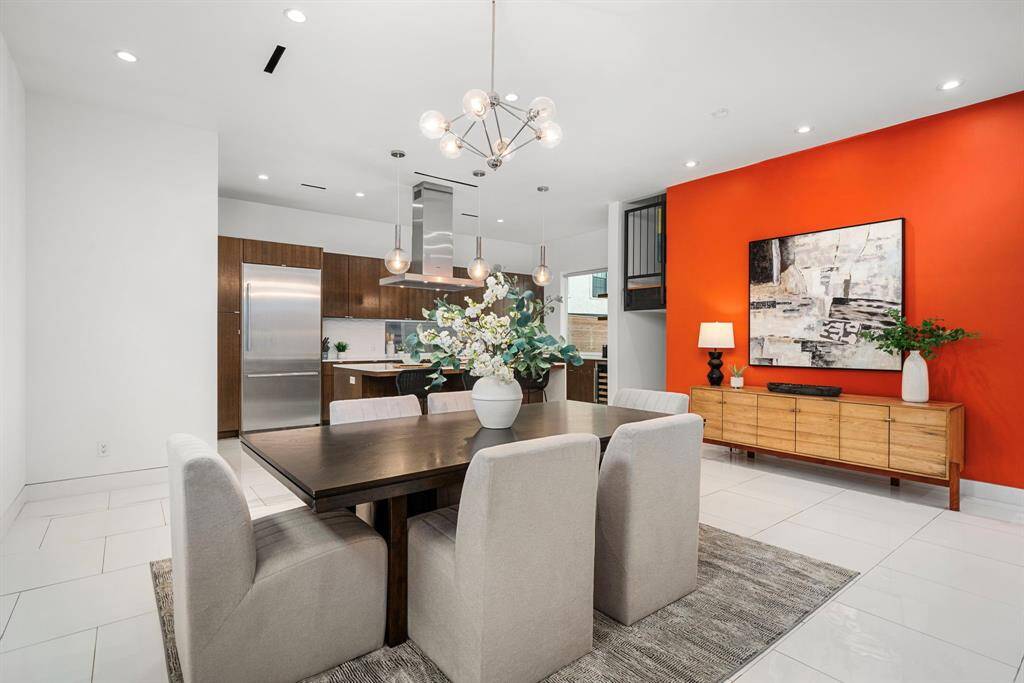 Dining overlooking kitchen.  Notice the continuation of neutral tile flooring with the pops of color that accent the space perfectly. Keep the orange...or add your personal touch or color!