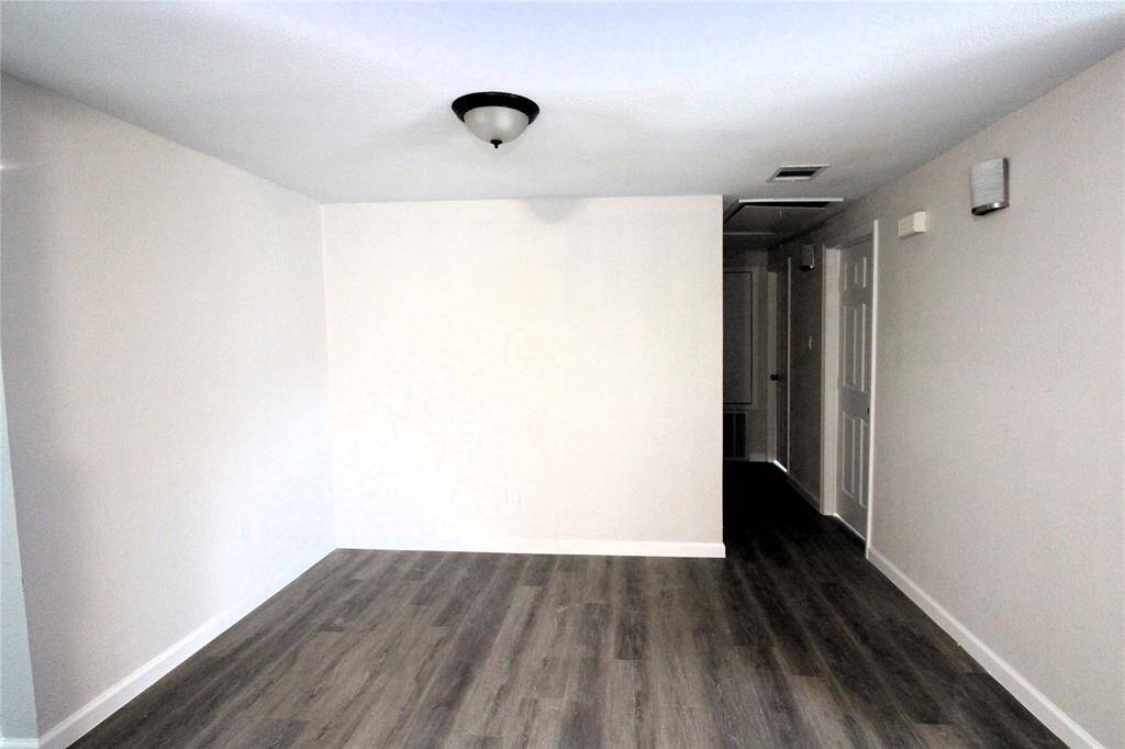 Dining room features modern laminate plank flooring and neutral walls.