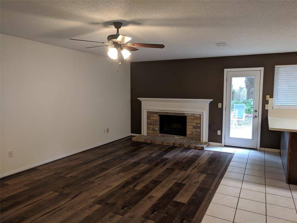 Living room with wood burning fireplace and vinyl wood floor
