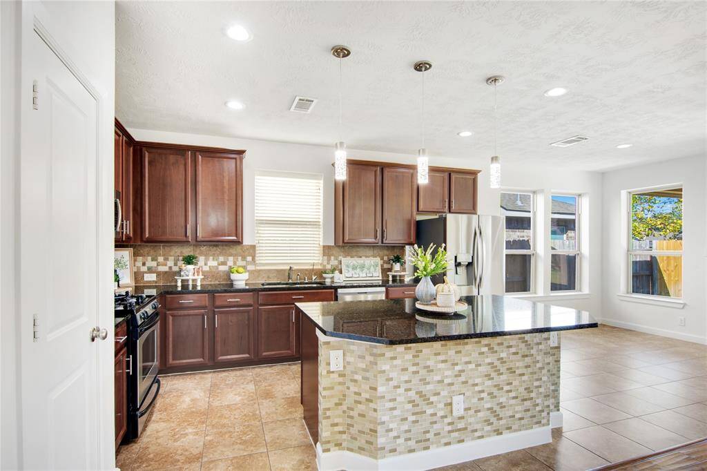 The island kitchen is a chef's dream, featuring stunning granite countertops that provide both style and functionality. Equipped with sleek stainless steel appliances, it combines modern convenience with a polished aesthetic. Upgraded pendant lighting hangs above the island, adding a touch of elegance while ensuring the space is bright and welcoming for both cooking and entertaining.