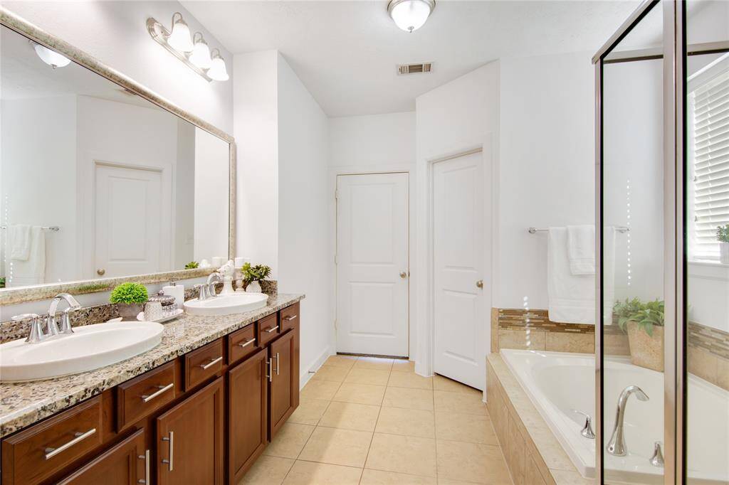 The primary ensuite is a luxurious retreat, featuring dual sinks for added convenience and a spacious soaking tub that invites relaxation. A walk-in shower offers a modern touch, while the generous walk-in closet provides ample storage, making this sanctuary both functional and indulgent.