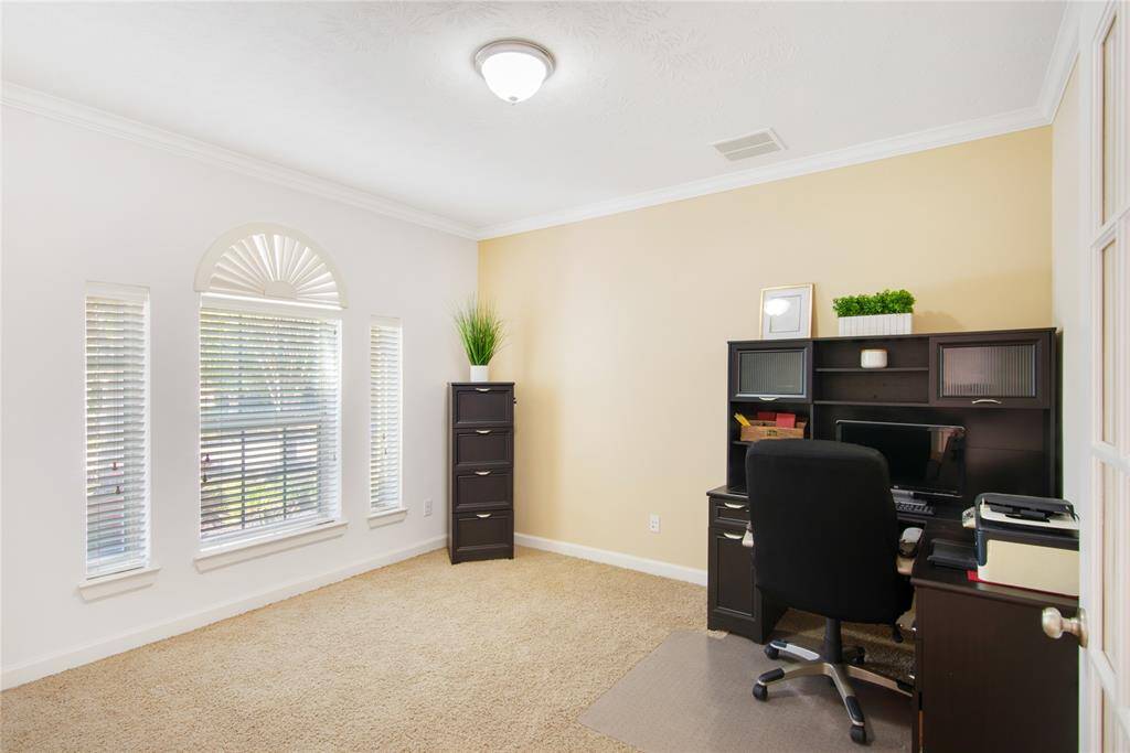 The study, featuring beautiful French doors, floods the space with natural light, creating a bright and airy atmosphere perfect for inspiration. Overlooking the front yard, it offers a serene view that invites creativity while providing a peaceful retreat for focused work or reading.