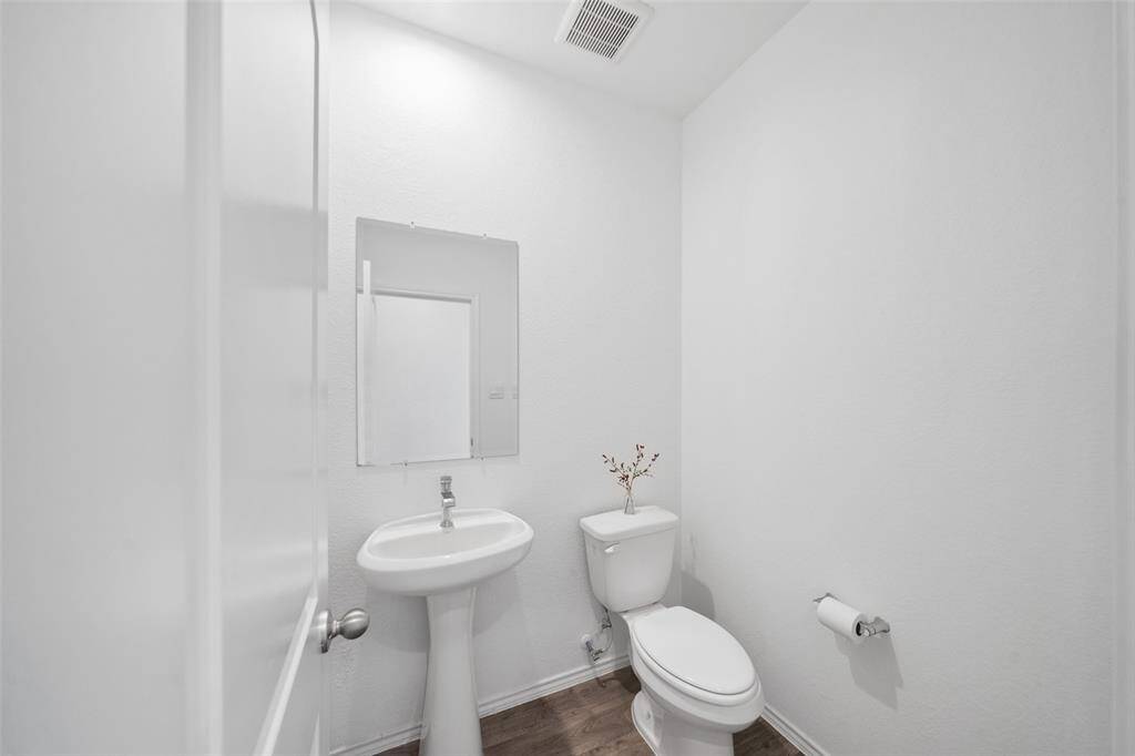The half bath near the kitchen and front door combines modern style with convenience, offering a polished and welcoming touch.