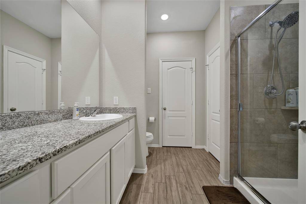 This primary bathroom boasts a walk-in shower and paired with ample counter space to keep everything organized.
