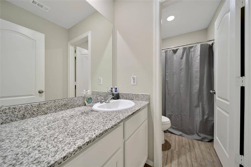 The secondary bathroom features a clean design and all the essentials for everyday use.