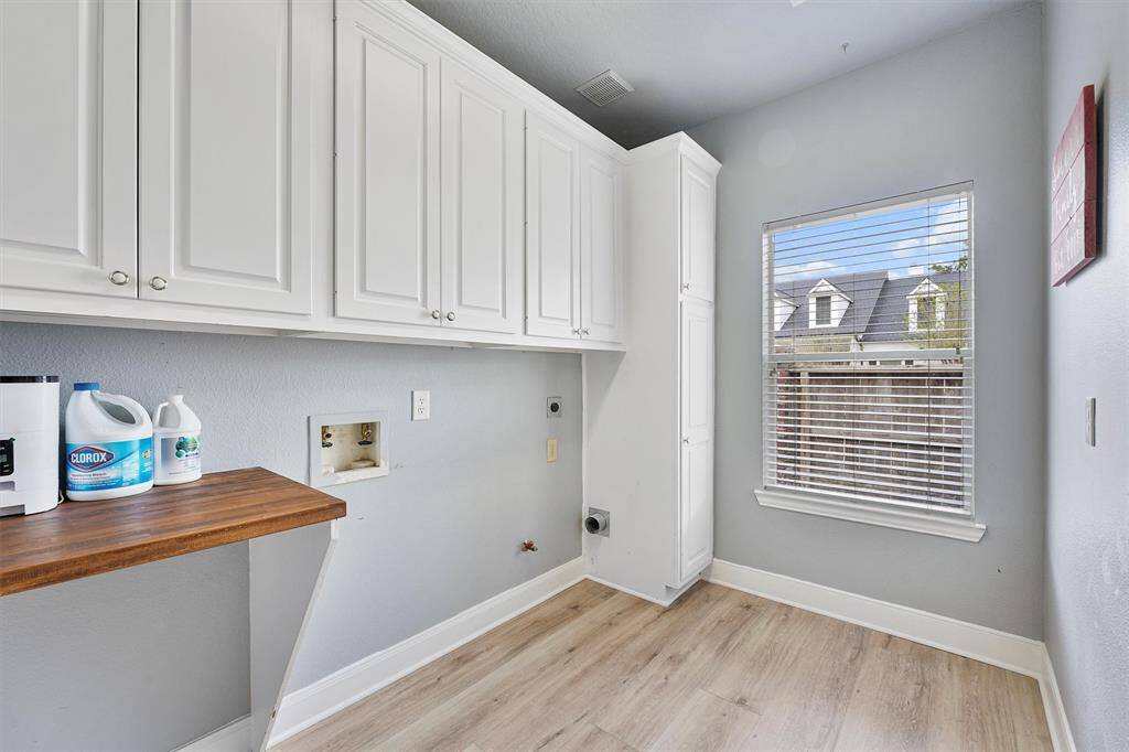 Oversized laundry room with lots of cabinets for storage and room for a refrigerator