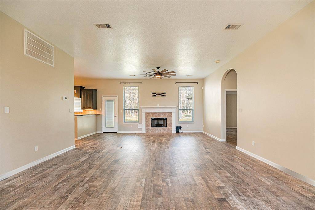 The living area offers a charming fireplace and large windows, a perfect gathering space.