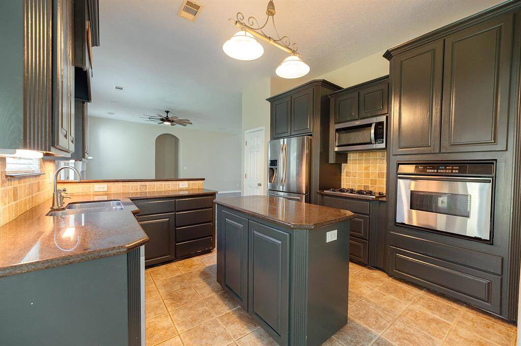 Prepare meals with ease in this well-appointed kitchen, offering both style and functionality.