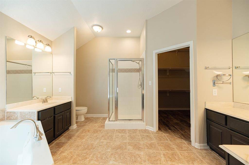 Luxurious primary bathroom with modern fixtures, dual sinks, and a spa-like soaking tub for ultimate relaxation.