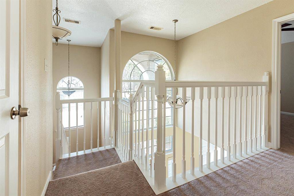 The gorgeous entryway windows flood the lofted staircase area with bright natural light.
