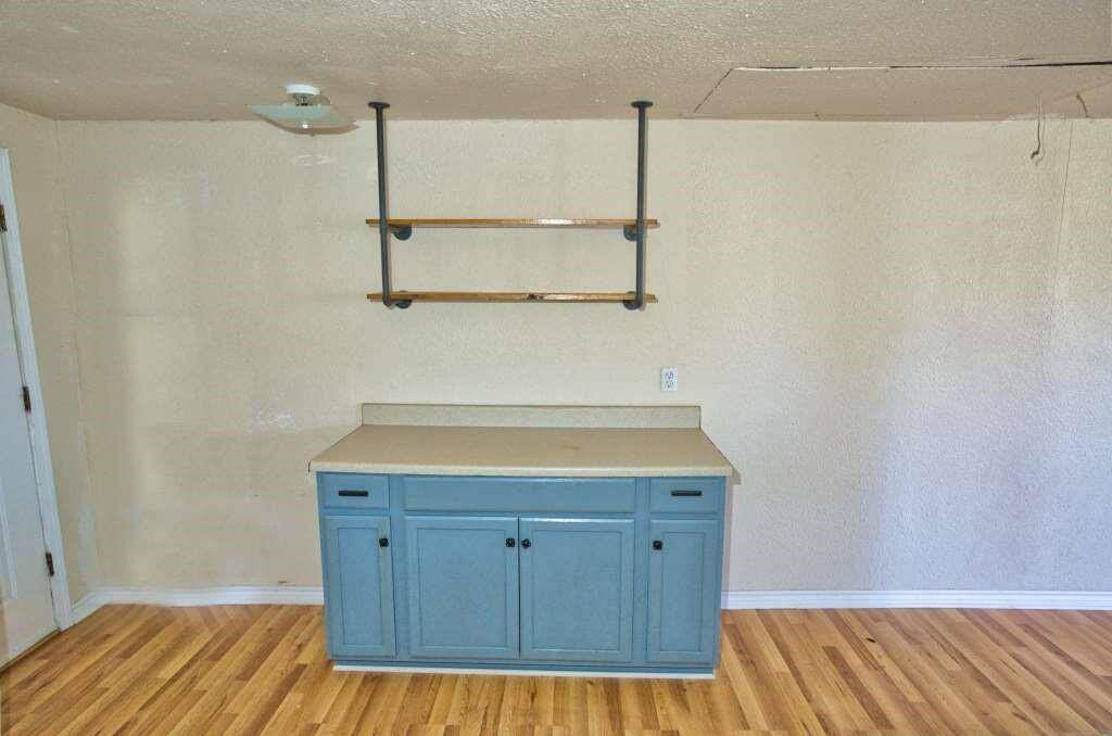 Open shelving provides additional storage, and soft lighting creates a warm atmosphere.