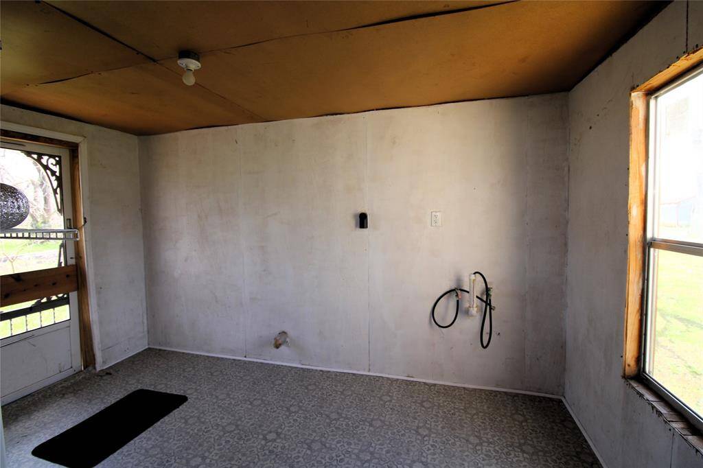 This is a functional laundry room featuring washer and dryer connections, shelving for storage.