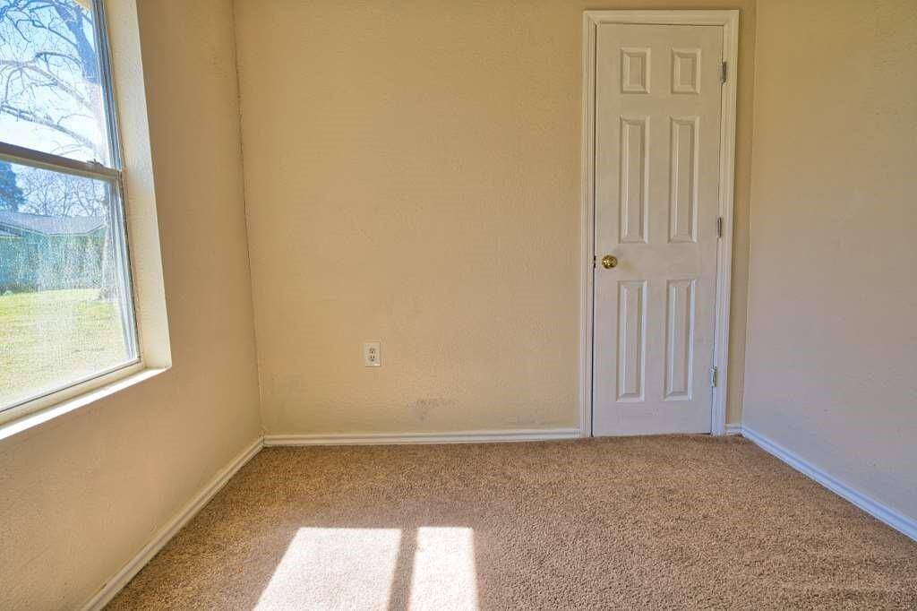 This cozy room features neutral walls, a window for natural light and closet. Making it ideal for a small bedroom or office space.