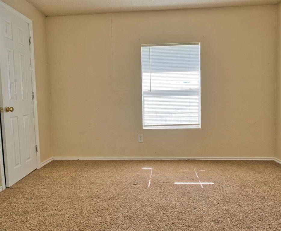 Primary room features neutral walls, windows for natural light and closet.