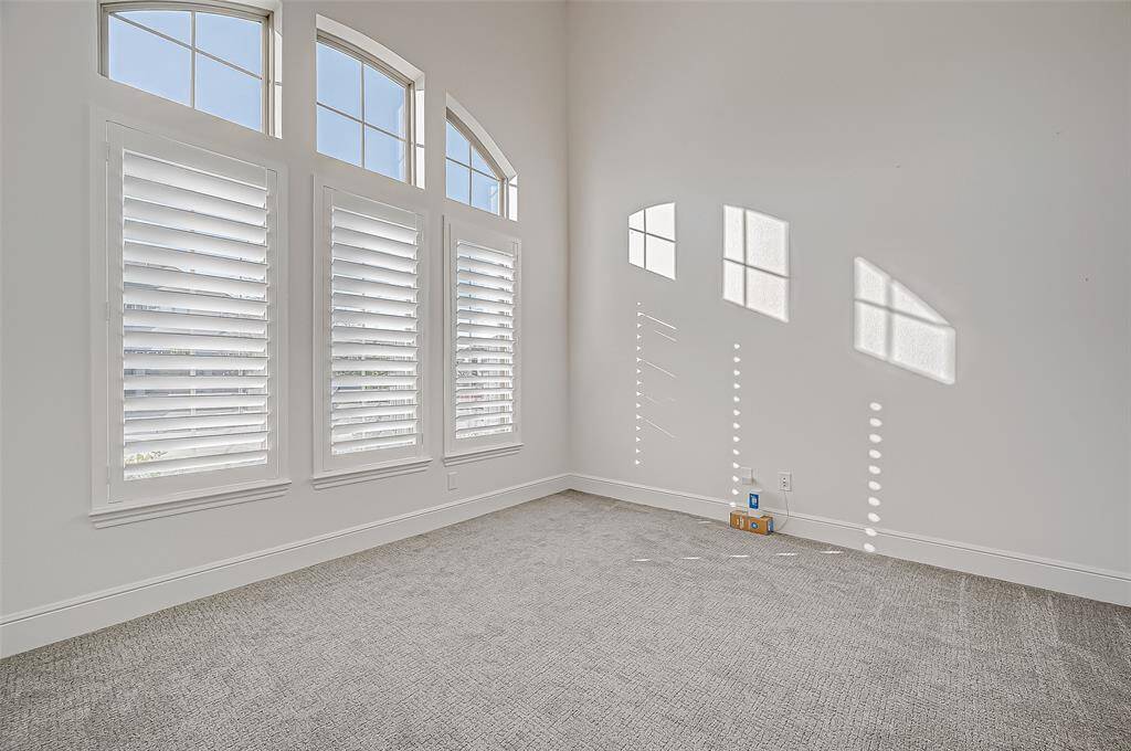 Home Office: Situated at the front of the home, this refined space features double glass doors, high ceilings, and classy plantation shutters providing ample natural light with views of the beautifully landscaped front yard.