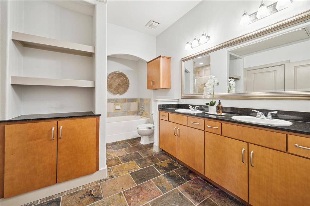Discover tranquility in this pristine bathroom, offering ample space and storage to craft your personal spa oasis at home.