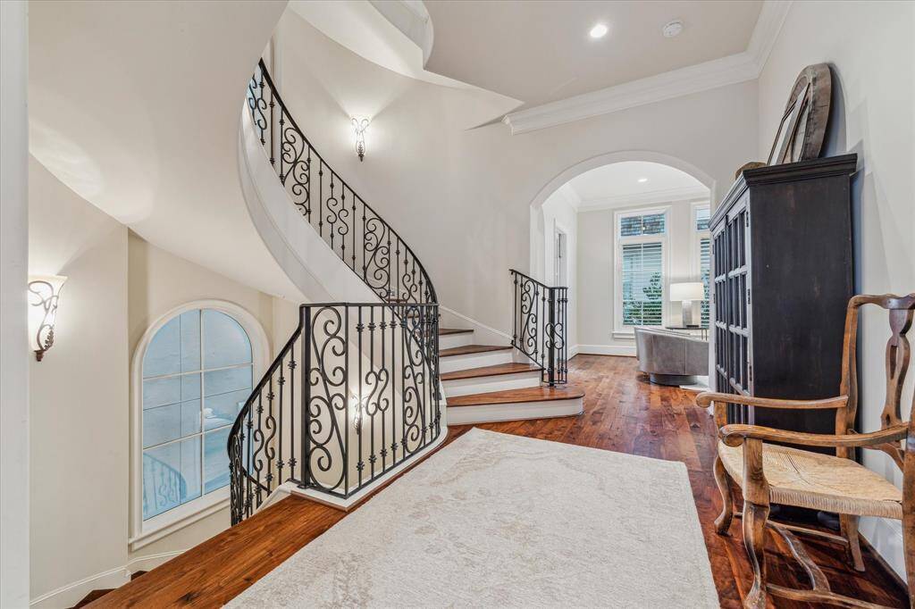 Second floor gallery with arched opening to family room and door to powder bath.