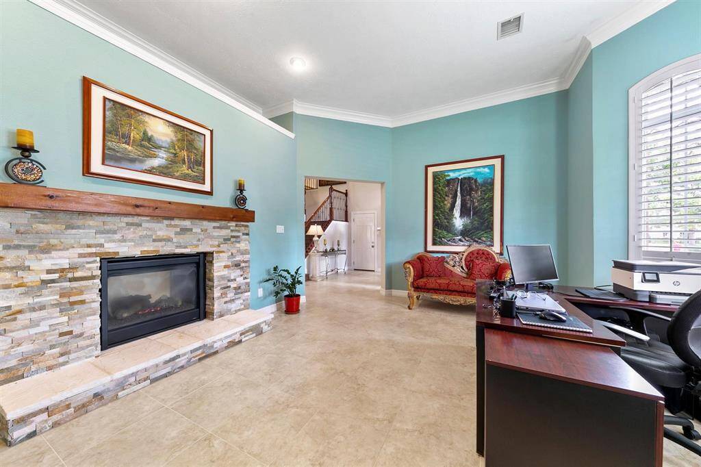 The formal living room features a dual-sided fireplace that also serves the adjacent formal dining room, creating a warm and inviting ambiance.