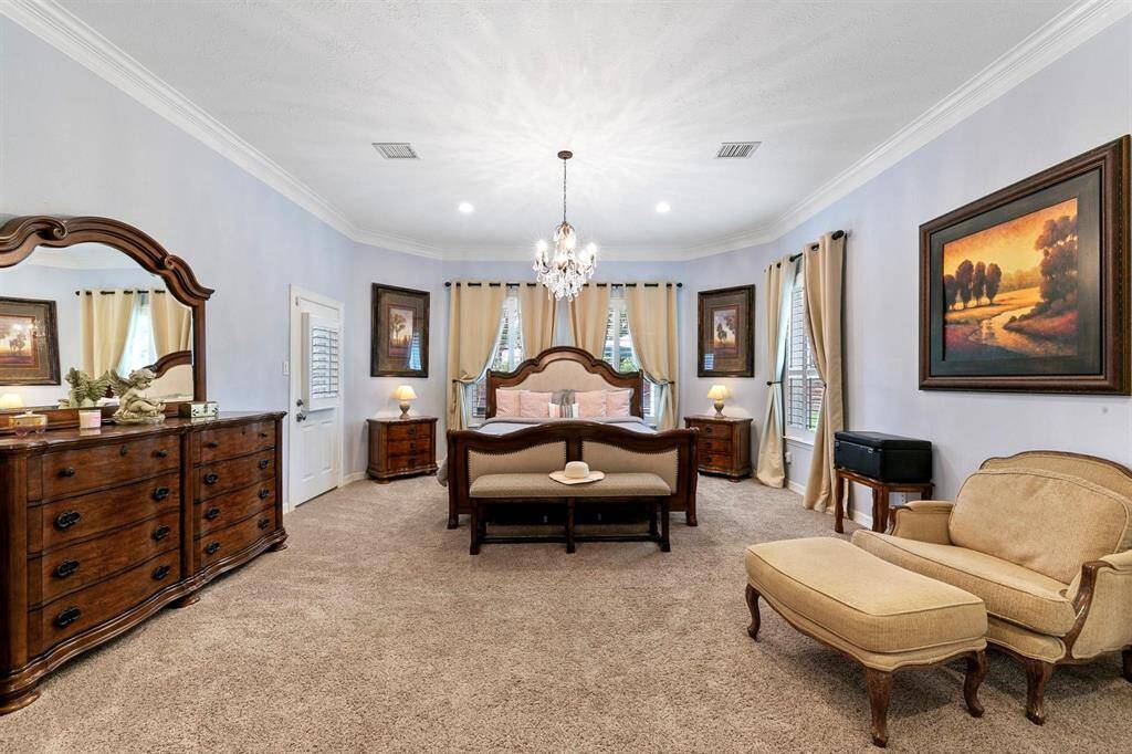 The generously sized primary suite offers ample space for a comfortable sitting area. It also features private access to the backyard, providing a serene retreat with outdoor convenience.