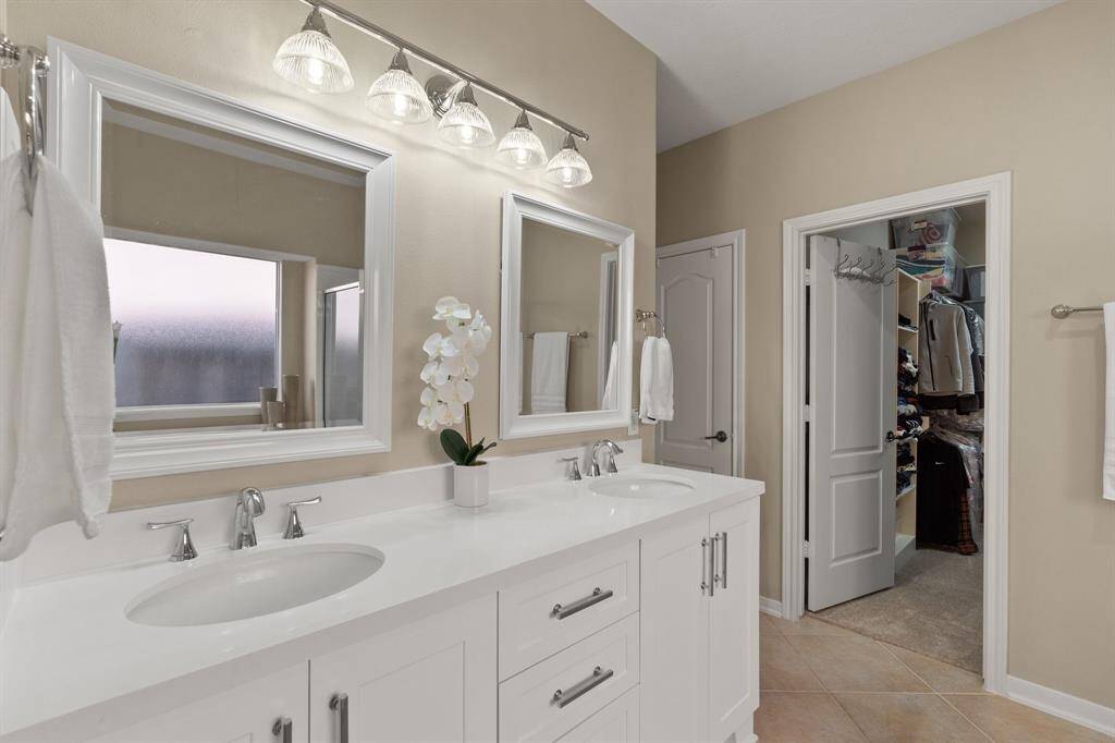 Primary bathroom includes double vanity, double mirrors, plenty of storage and space.