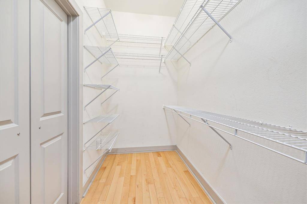 This is only half of the spacious walk-in closet, featuring a smart rod and shelf system for optimal storage.