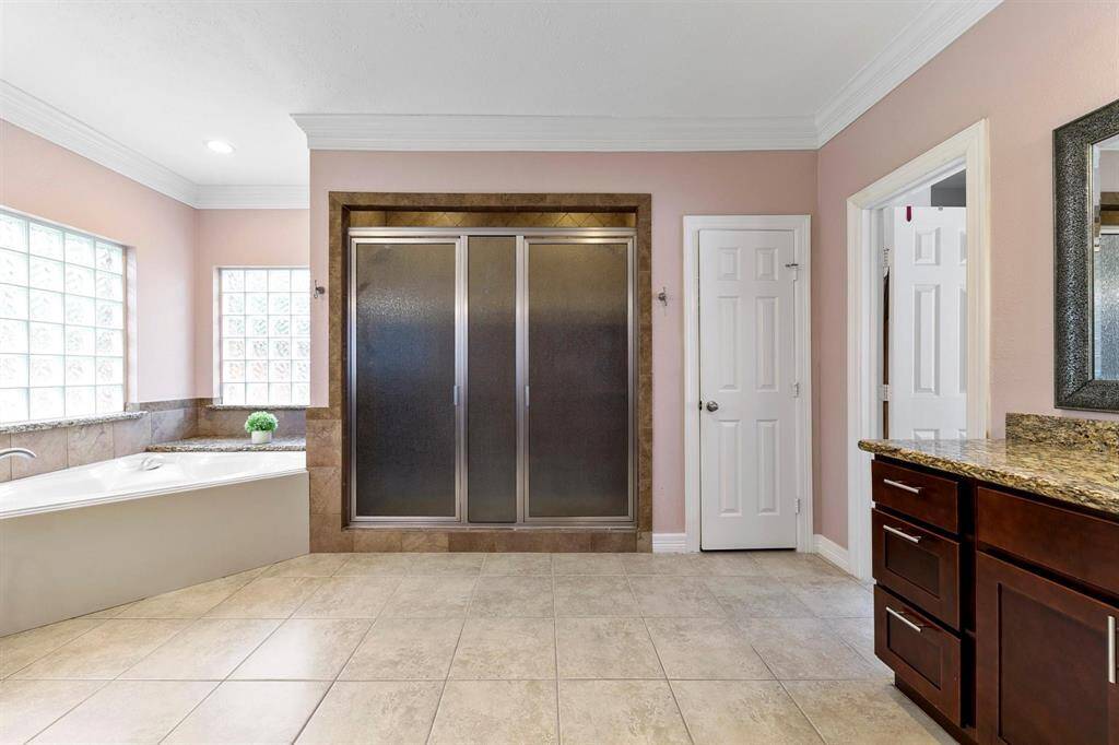 The primary en-suite includes a luxurious garden tub and a separate shower, providing a spa-like experience.