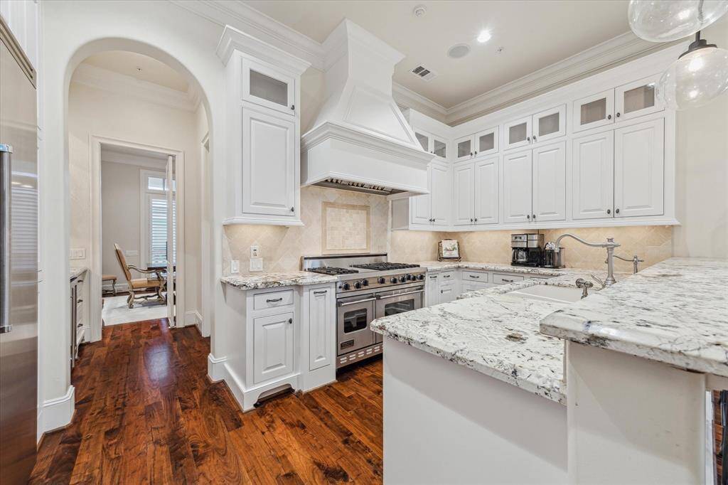 Kitchen with granite countertops, tumbled marble backsplash, and stainless 6 burner Viking range with griddle & double ovens.