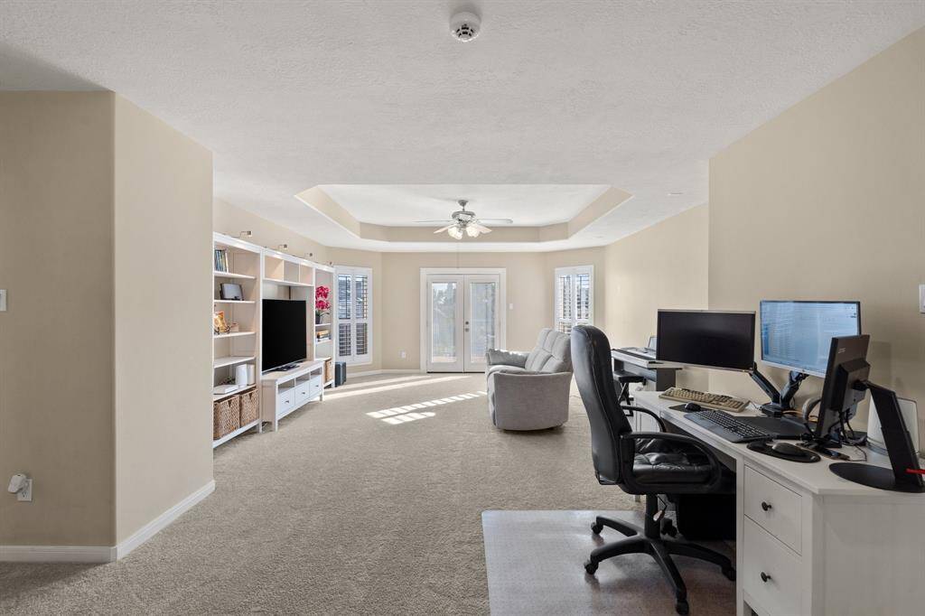 View from the top of the stairs into this massive game room.  This space can hold a lot of furniture, a large entertainment center, a desk, or could be used as a workout room.  The double doors at the end of the game room lead to the balcony.