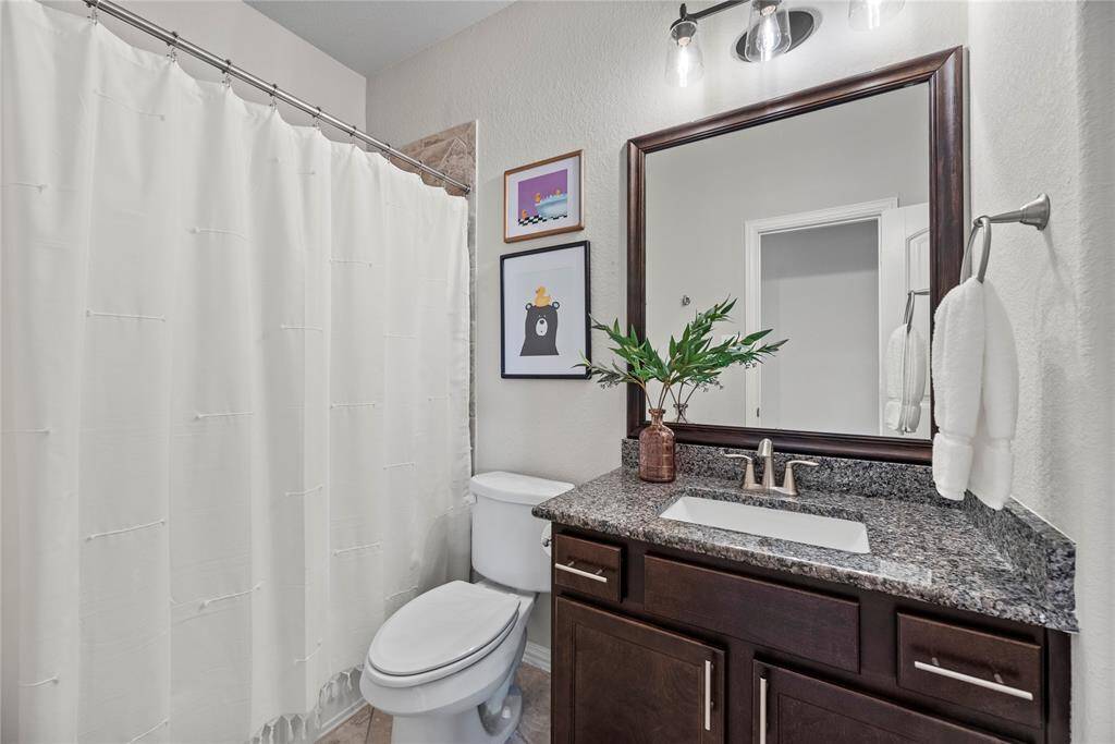 Secondary bathroom with tub/shower combo and granite counter tops.