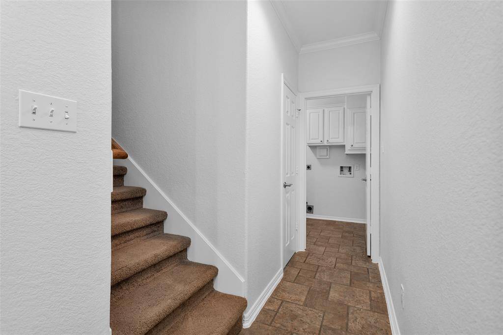 From the kitchen we head to the stairs and down the hall to the utility/mud room.