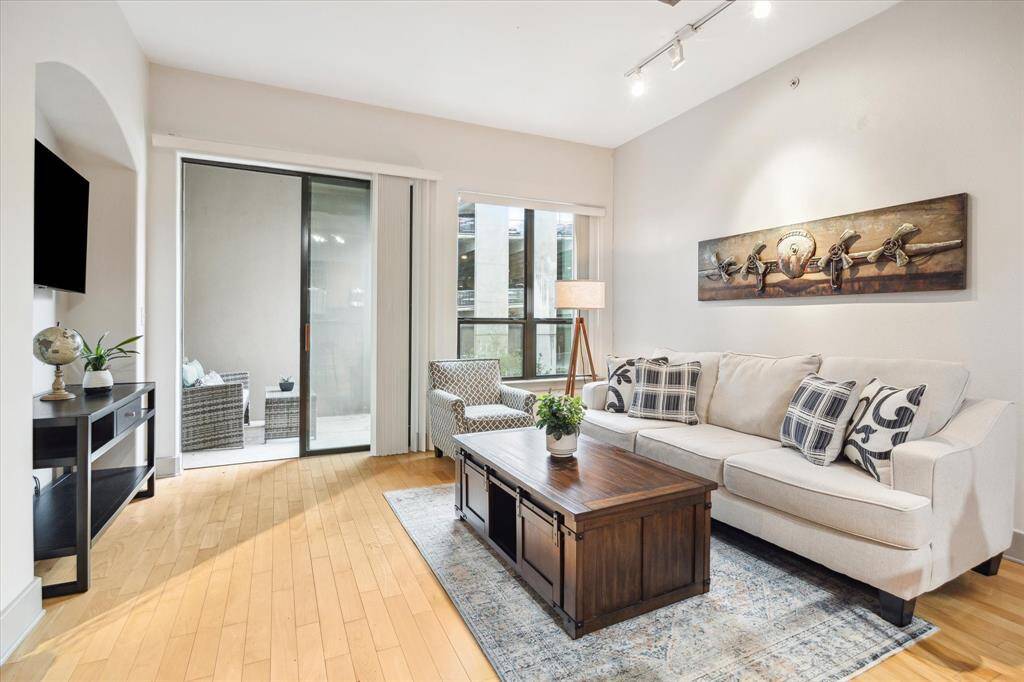 This bright living area opens to a balcony and features versatile space for furniture, plus a dedicated nook for a TV or art display.