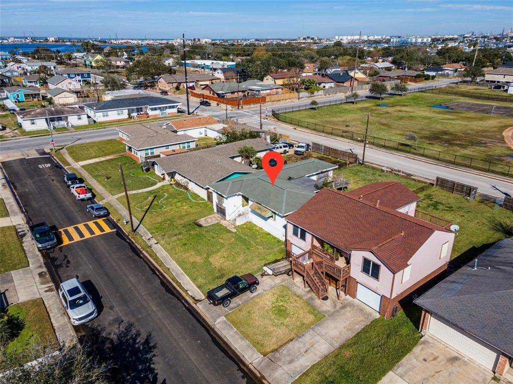 This aerial photo shows a residential neighborhood with a highlighted house. The property features a spacious yard and a driveway. It's located on a quiet street with nearby amenities, including a park. The area appears to be well-maintained and offers a suburban setting.