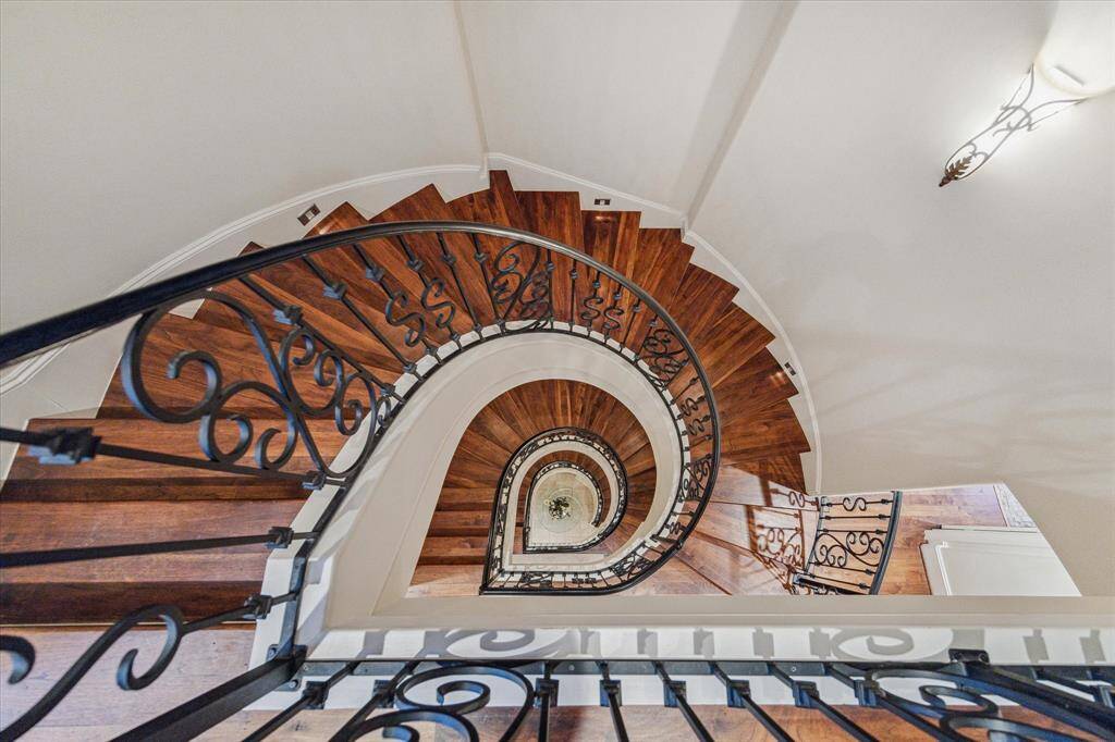 Circular staircase with wooden treads & risers.  Wrought iron balustrades & handrail