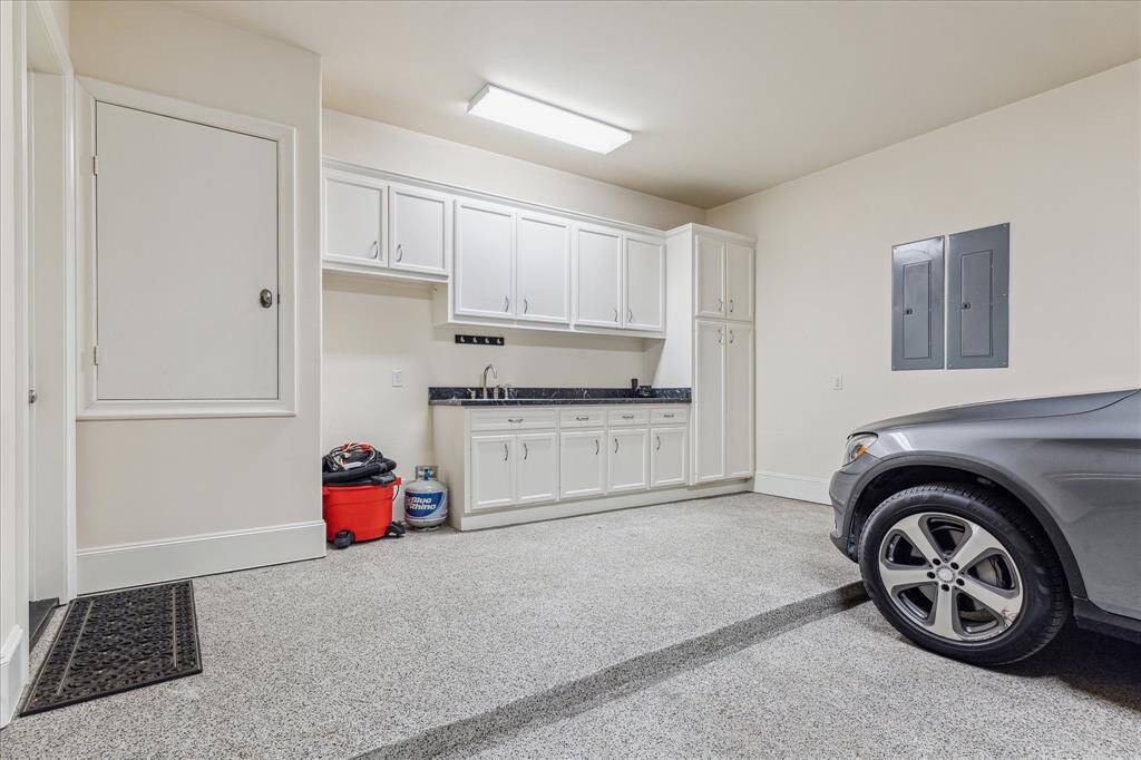 Two car attached garage.  Epoxy floor, drawer & cabinet storage, sink with counter space & recessed area for extra refrigerator