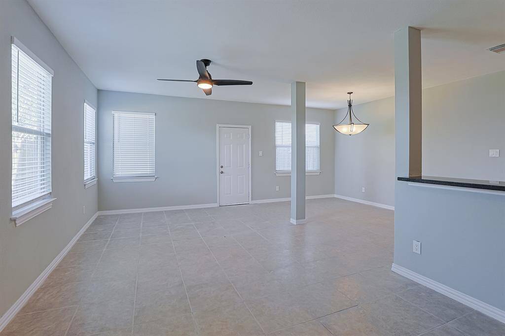Step into this spacious and bright living room, where natural light pours through large windows, creating a warm and inviting atmosphere.