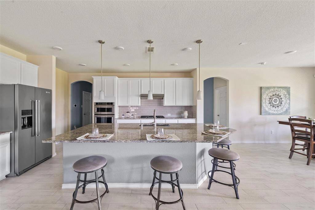 This kitchen features a massive island, tons of cabinet space, and gorgeous appliances.