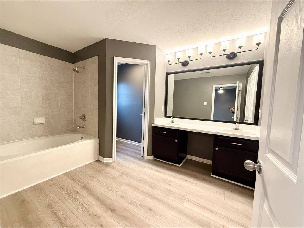The fully renovated primary bathroom is a standout feature, offering a double-sink vanity, stylish lighting, and a beautifully tiled shower, perfect for starting or ending your day in luxury.