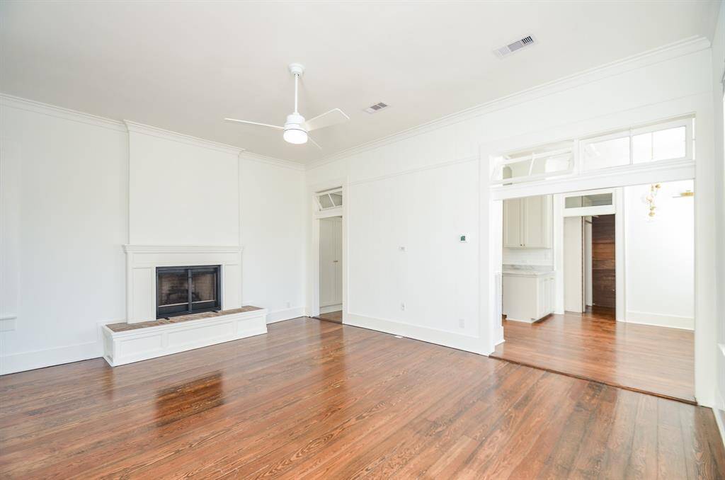 Living area has tons of natural light, high ceilings, beautiful refinished wood flooring (2021) & a cozy gas log fireplace. Living area flows into the kitchen/dining area with side door access to the rear deck.
