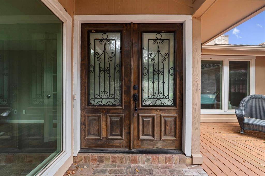 To enter the home, you must pass these beautiful double doors, furnished with wrought iron decoration and privacy glass.