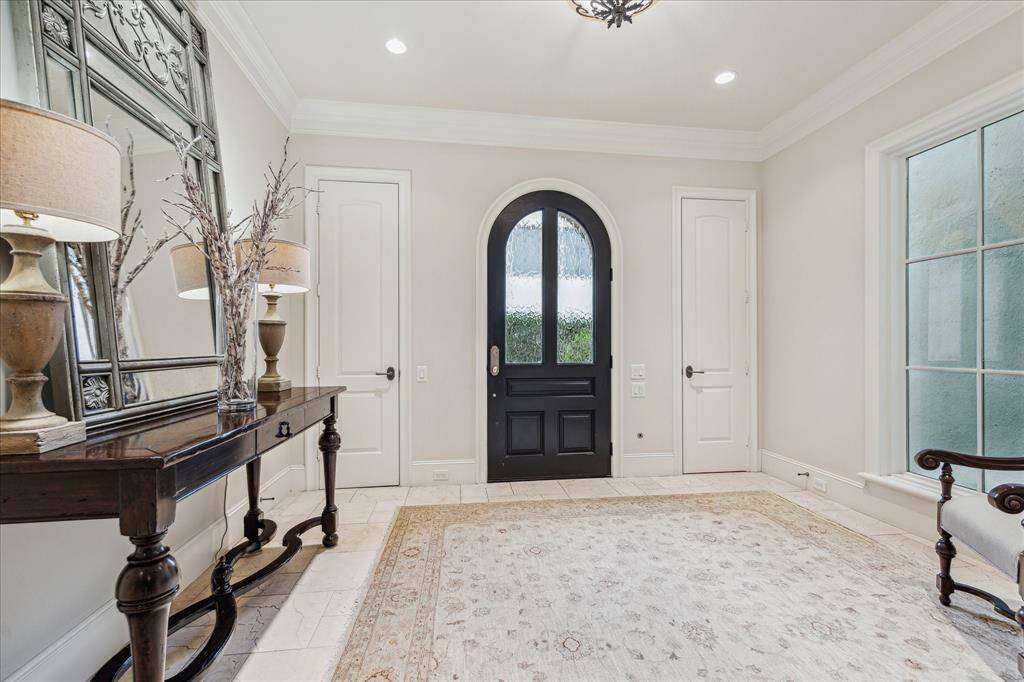 Foyer with two coat closets and solid wood door with privacy glass.