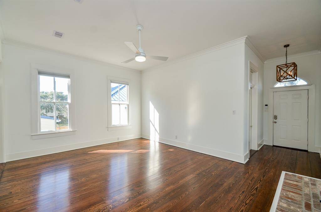 Living area has tons of natural light, high ceilings, beautiful refinished wood flooring (2021) & a cozy gas log fireplace.