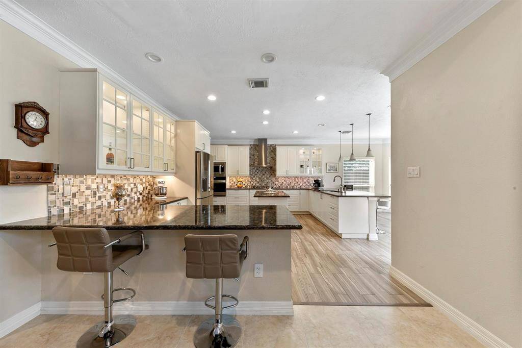 The kitchen, open to the family room, includes a convenient breakfast bar for casual dining and entertaining. Its seamless layout enhances connectivity and flow between the cooking and living spaces.