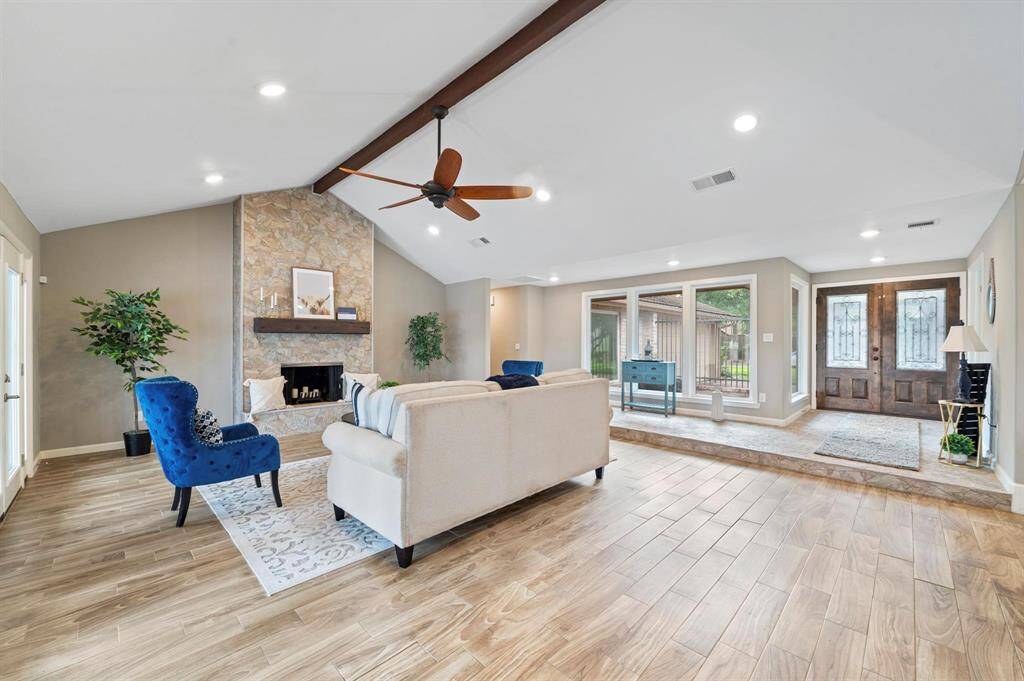 The living room features a statement mantle piece and a gorgeous fireplace. With the massive windows that surround the space, you are basking in the natural light that they provide.