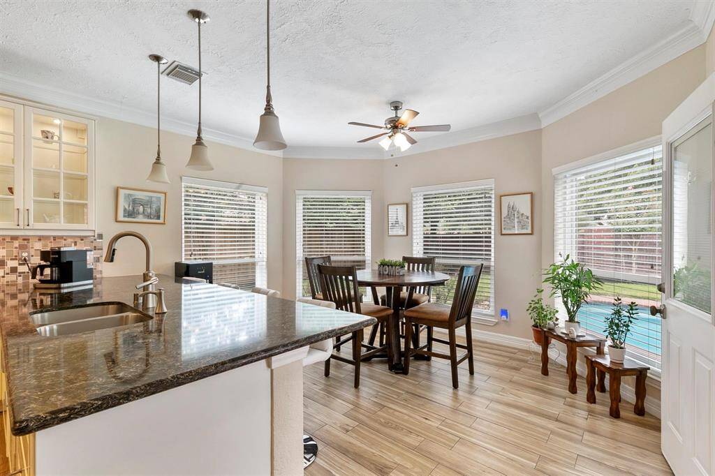 The breakfast area boasts a charming bay window and an additional breakfast bar, creating a cozy spot for casual meals. It also offers easy access to the backyard, perfect for indoor-outdoor dining.